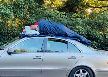 Shocked resident of deluged Lakes snaps men asleep on roof of their car