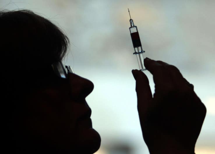 Woman holding a syringe in silhouette
