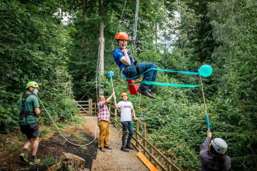 Oliver Voysey zips through reopening ribbons held by Charles and Lois Deans at the Lake District Calvert Trust