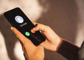 blockd number on a mobile phone in woman's hands