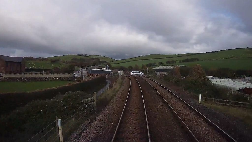 A shocking video has been released showing a car driver ignoring red lights at a level crossing and driving directly in front of an oncoming train near Barrow.