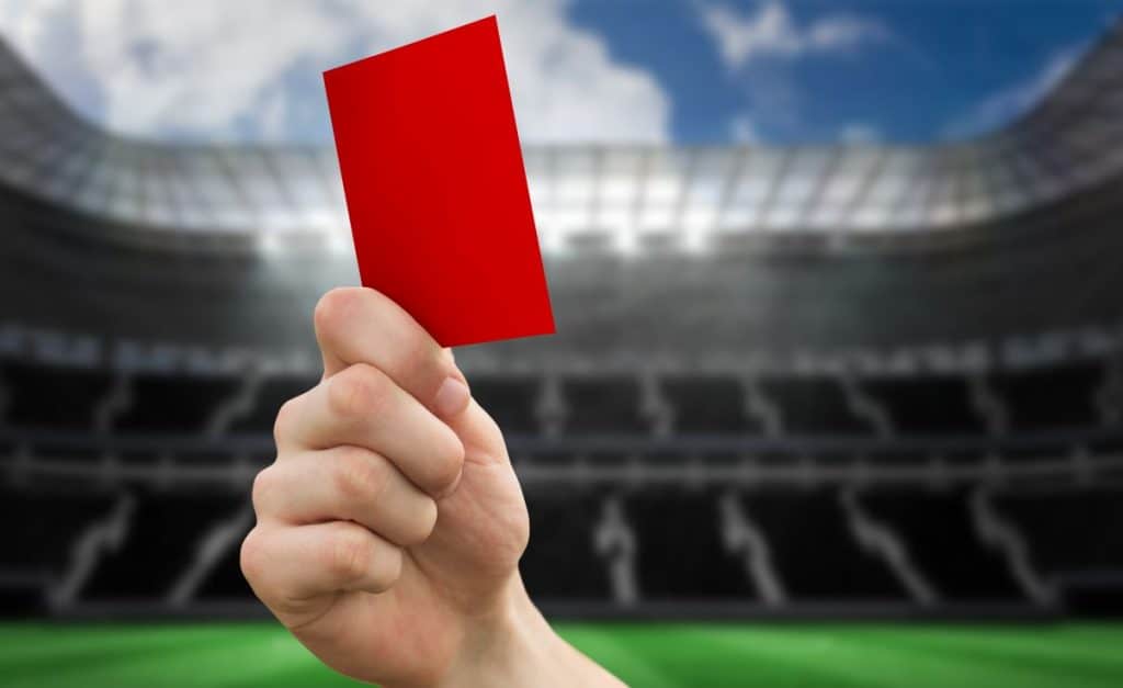 hand holding a red card in a stadium