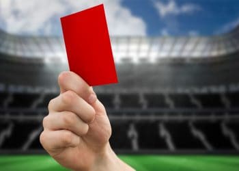 hand holding a red card in a stadium