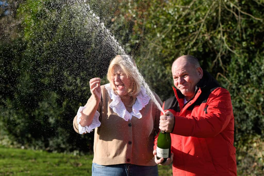 Ian Black, 61, and Sandra Black, 55, celebrate winning £2 million on a Monopoly Deluxe Scratchcard with their dog Meg, in Carlisle