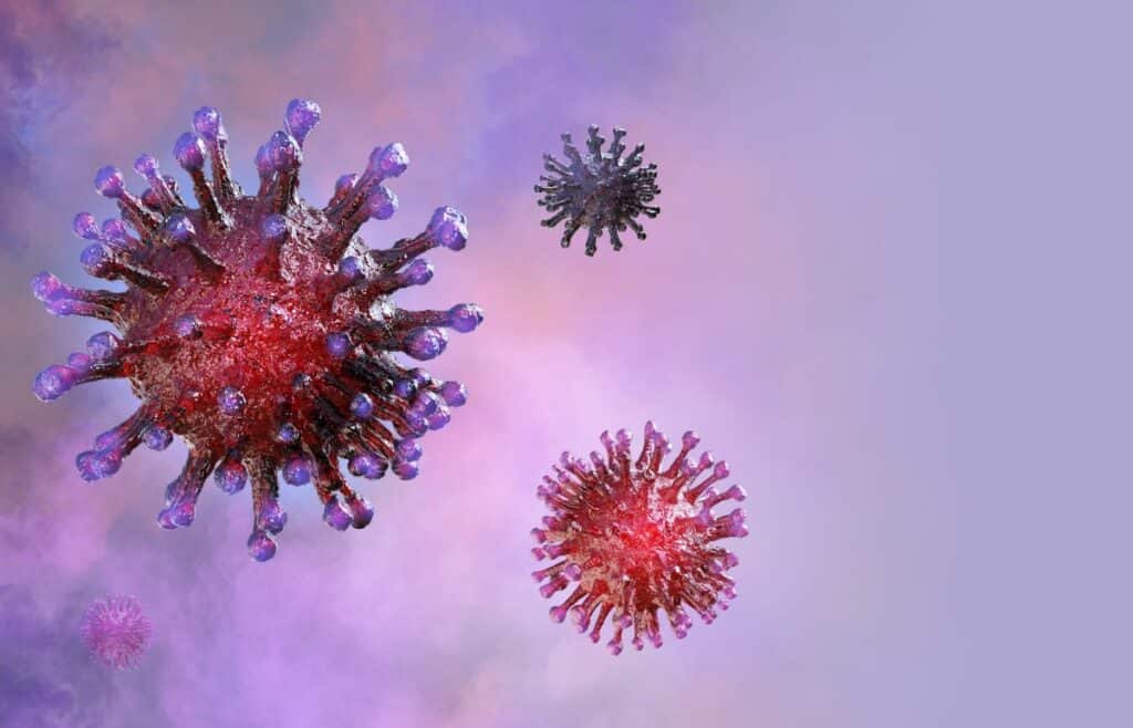 A model of the coronavirus is set against a pink background. 