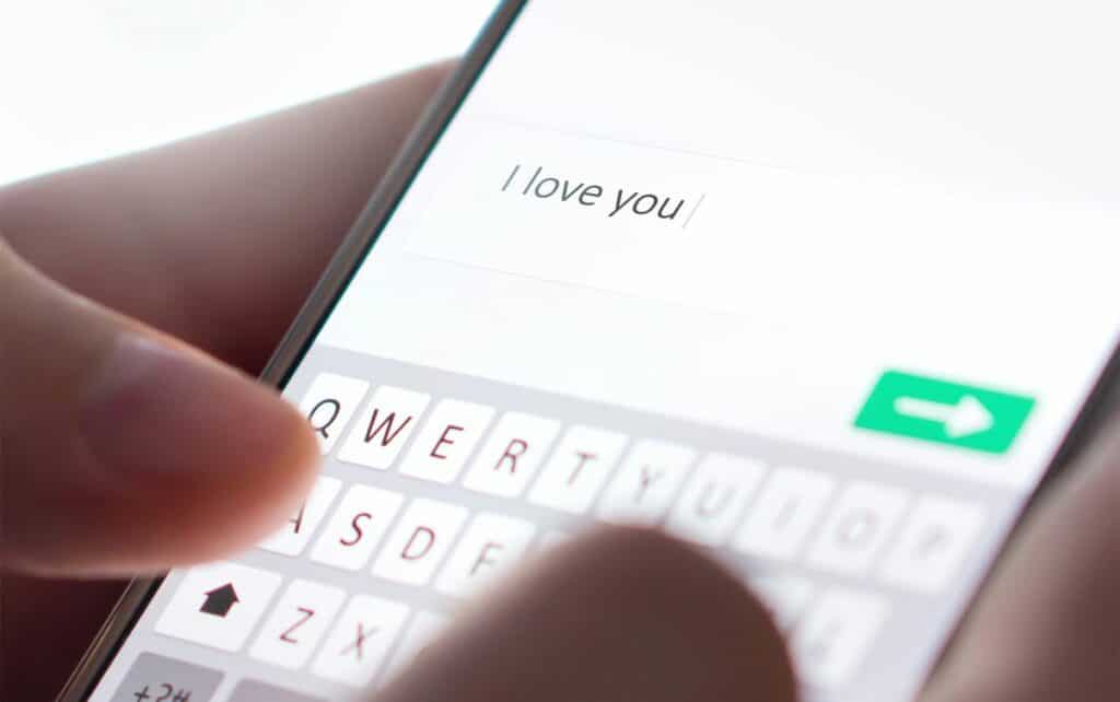 woman holding mobile phone with I love you message