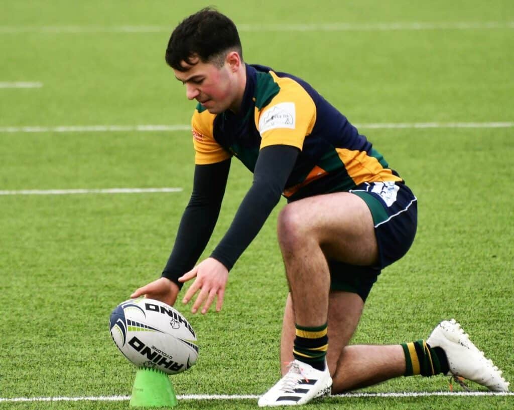 Good kicking from Keswick's Billy Thompson in wet, blustery conditions. He is pictured putting the ball down ready to kick in the black and orange strip of Keswick. Picture: Ben Challis