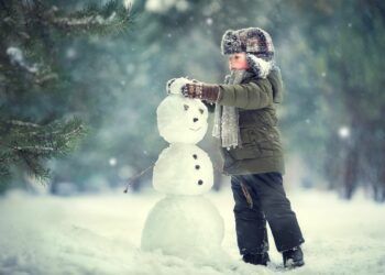child building snowman in a forest