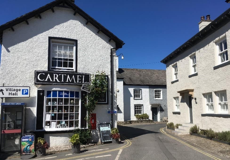 A picture of the traditional white buildings in Cartmel set against a blue sky