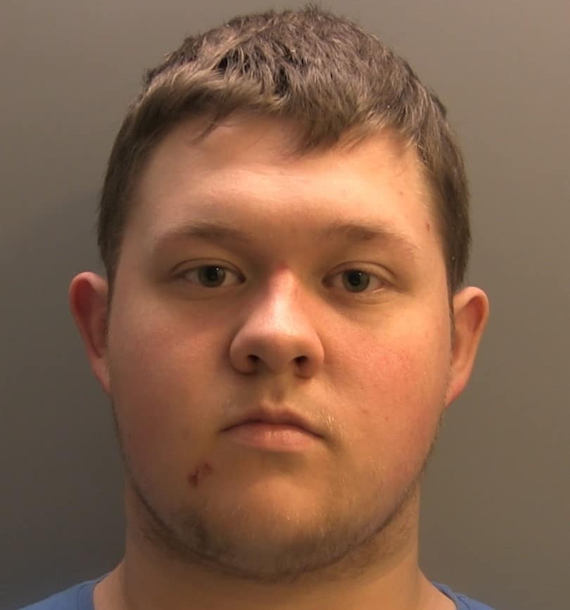 Connor Naylor has brown hair and is pictured against a grey background