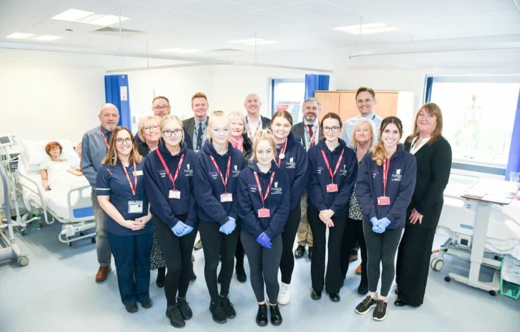 Students from Furness College pictured with Alex back left in the hospital bed