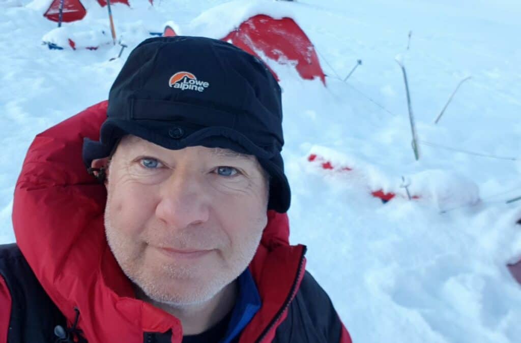Neil Jurd, OBE, pictured on his expedition in Greenland with the snow behind him