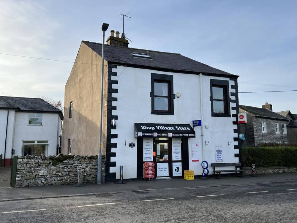A general view of Shap Village Store and Post Office. The store is painted white with black windows and a black front.