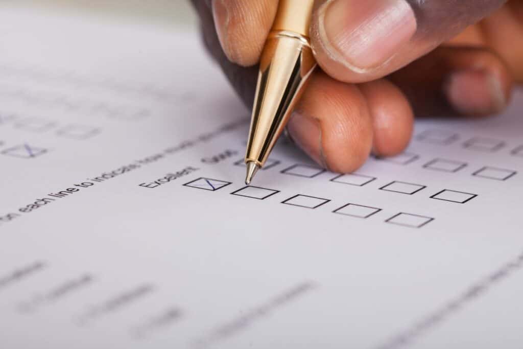 man holding pen filling out survey