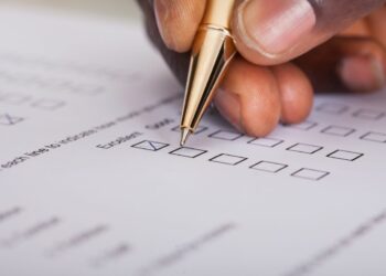 man holding pen filling out survey