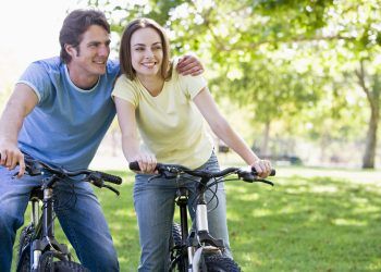 Couple,On,Bikes,Outdoors,Smiling