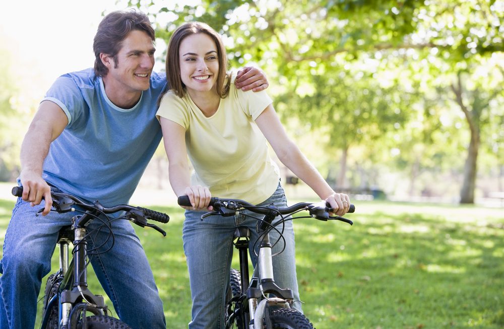 Couple,On,Bikes,Outdoors,Smiling