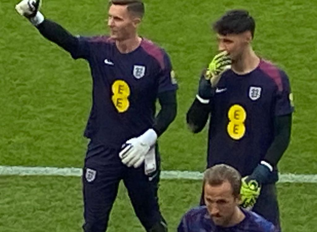 Dean Henderson and James Trafford pictured close up and walking across the pitch with Harry Kane in front of them